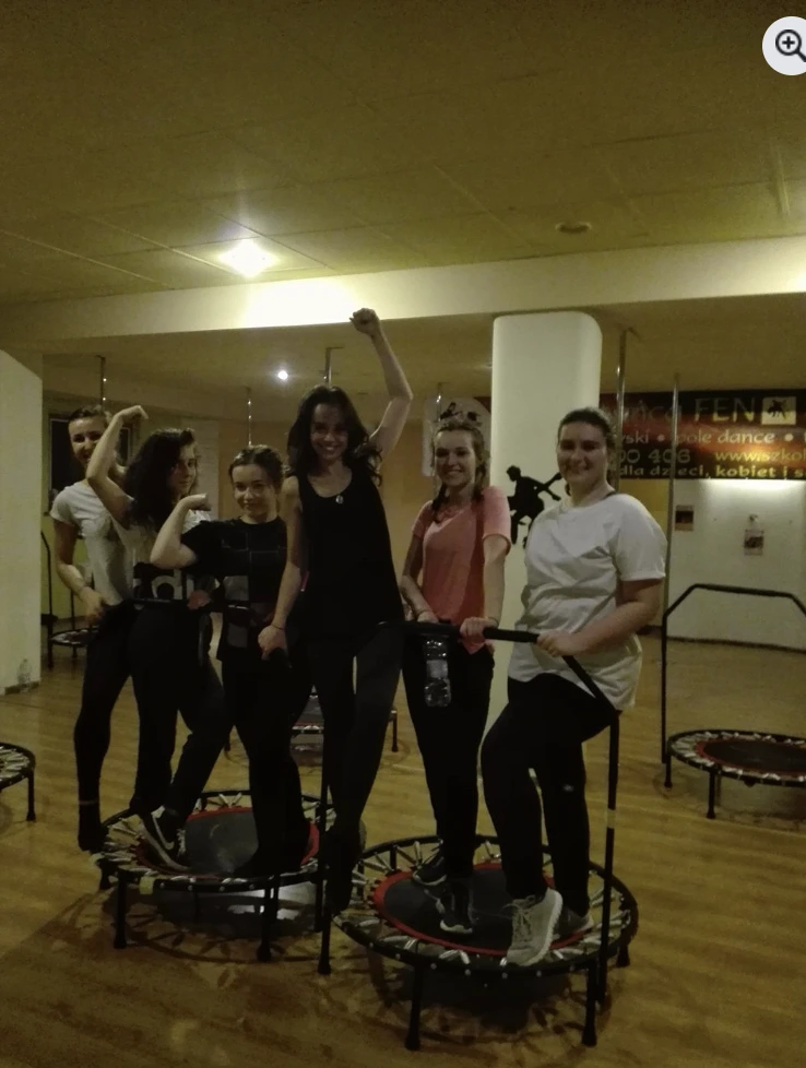 Grupa uczestników podczas treningu tanecznego na trampolinach
